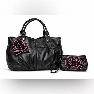 Stylish black faux leather handbag with matching wristlet, feat rosette accents